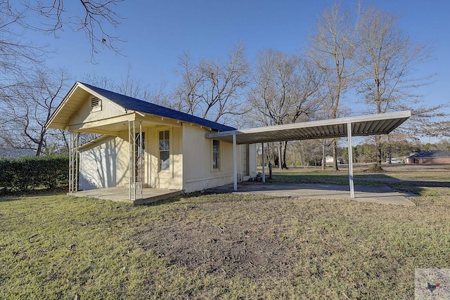 view of side of home featuring a carport and a yard