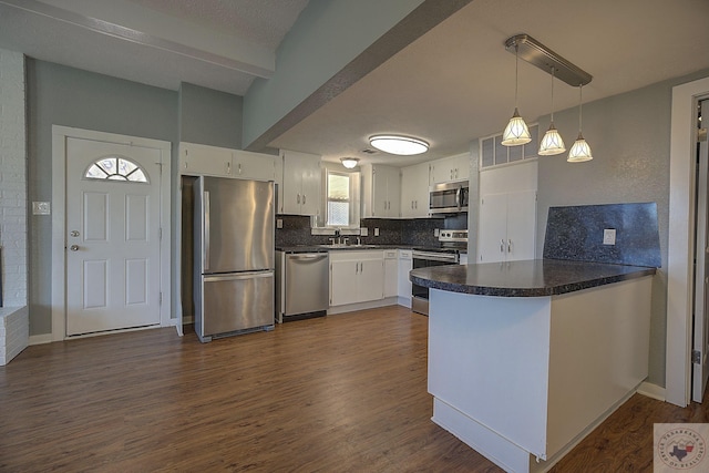 kitchen featuring decorative light fixtures, white cabinetry, appliances with stainless steel finishes, and tasteful backsplash