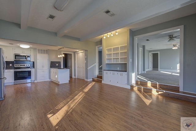 unfurnished living room with ceiling fan, beam ceiling, and dark hardwood / wood-style flooring