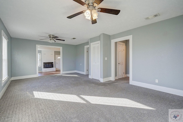 unfurnished living room with carpet floors and ceiling fan