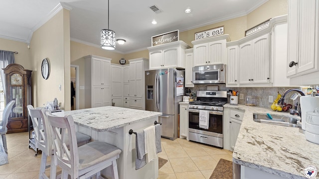 908 Arnold Ln, Texarkana, TX 75503 - kitchen with stainless steel appliances, crown molding, light tile patterned floors, backsplash, and light stone counters