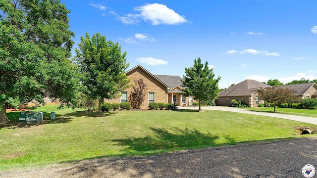908 Arnold Ln, Texarkana, TX 75503 - view of front of home featuring a front yard, brick siding, and curved driveway