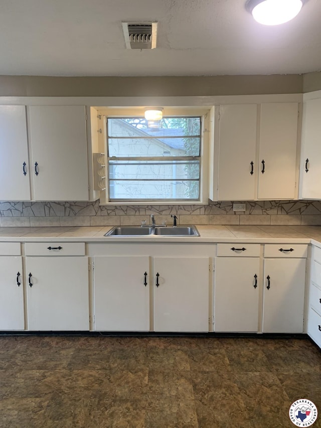 209 E 35th St, Texarkana, AR 71854 - kitchen with white cabinetry, light countertops, and backsplash