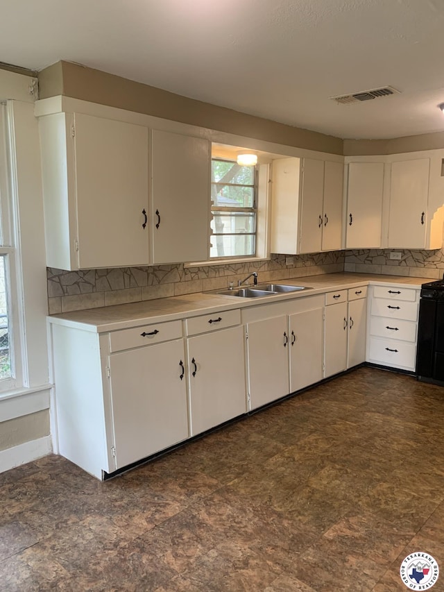 209 E 35th St, Texarkana, AR 71854 - kitchen featuring tasteful backsplash, white cabinets, and light countertops