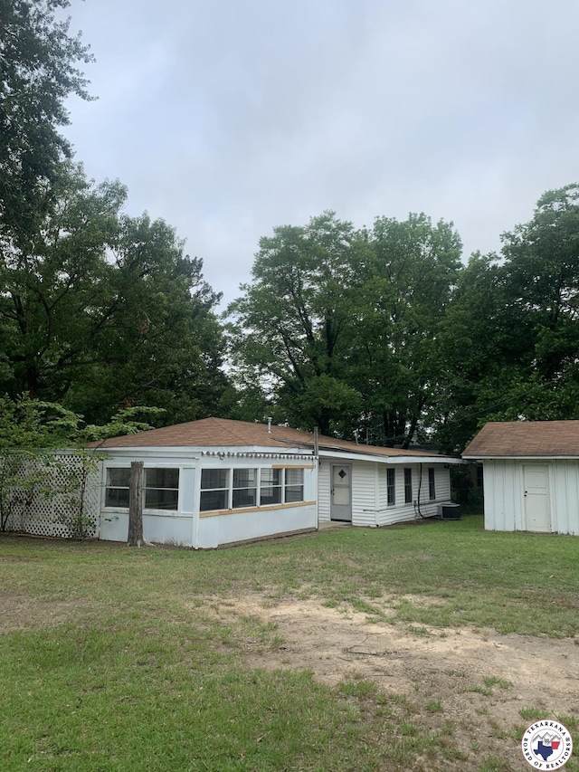 209 E 35th St, Texarkana, AR 71854 - view of front of house featuring a shed, a front yard, and a sunroom