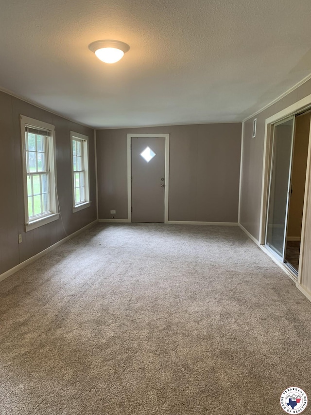 209 E 35th St, Texarkana, AR 71854 - carpeted entryway featuring a textured ceiling and baseboards