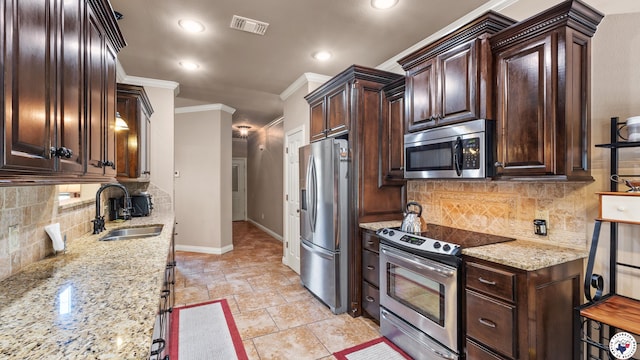 6 Stonewall Cir, Texarkana, TX 75503 - kitchen featuring stainless steel appliances, recessed lighting, crown molding, dark brown cabinets, and light stone countertops