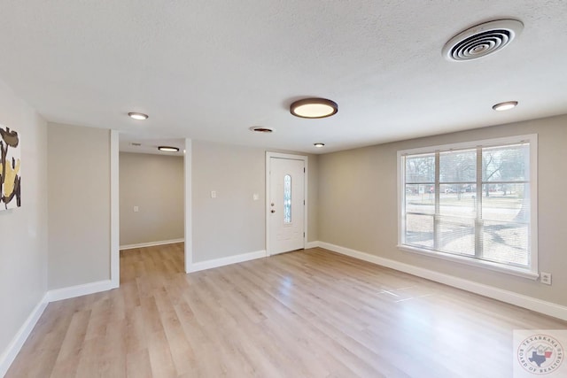 entryway with light wood-type flooring, baseboards, and visible vents