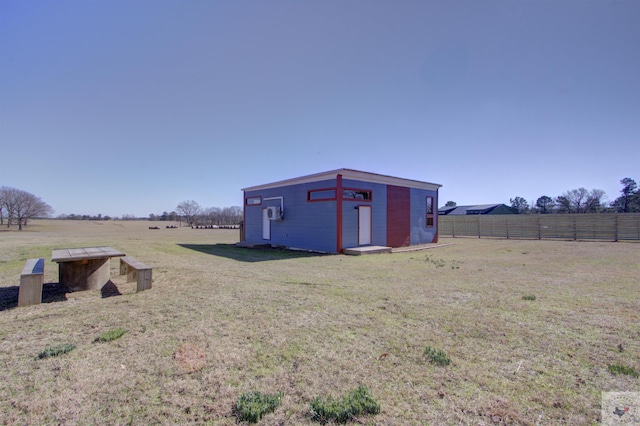 view of outbuilding featuring a rural view and a yard