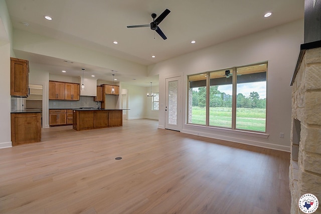 101 Ranch Rd, Texarkana, TX 75503 - unfurnished living room featuring ceiling fan, recessed lighting, baseboards, light wood finished floors, and a stone fireplace