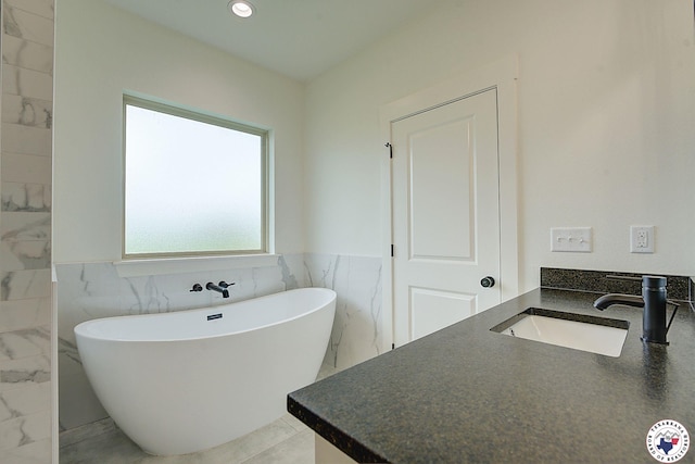 101 Ranch Rd, Texarkana, TX 75503 - bathroom with a freestanding tub, a wainscoted wall, tile walls, and vanity