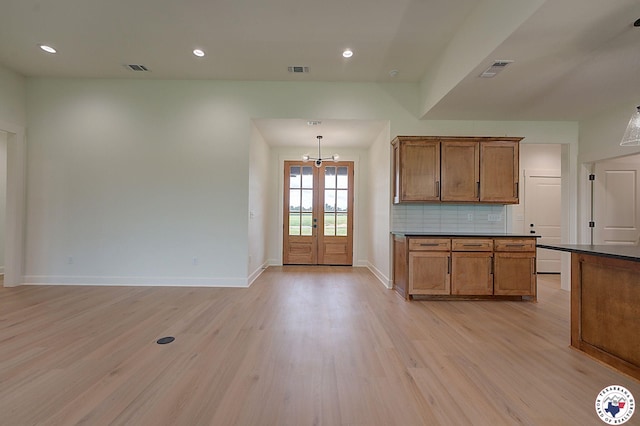 101 Ranch Rd, Texarkana, TX 75503 - kitchen with dark countertops, light wood-style flooring, brown cabinetry, tasteful backsplash, and baseboards