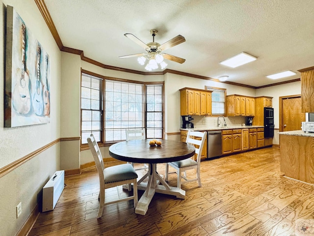 4604 Suzanne Dr, Texarkana, TX 75503 - dining area featuring light wood-style flooring, a ceiling fan, a textured ceiling, crown molding, and baseboards