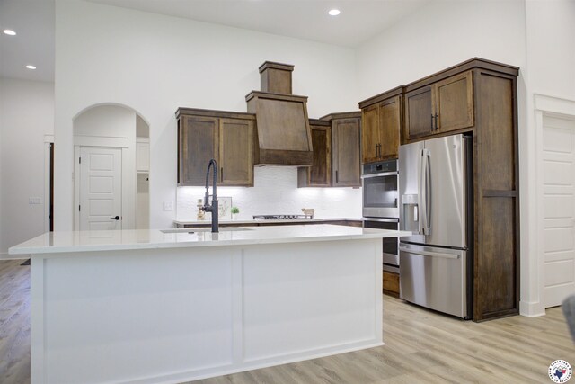 5616 Deaton Pl, Texarkana, TX 75503 - kitchen featuring stainless steel appliances, arched walkways, a sink, light wood-style flooring, and recessed lighting