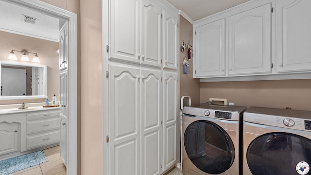 905 Lakeridge Ln, Texarkana, TX 75503 - laundry area featuring washer and dryer, cabinet space, and light tile patterned flooring