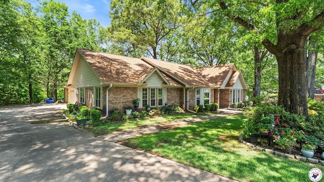 905 Lakeridge Ln, Texarkana, TX 75503 - view of front of home featuring brick siding, driveway, a front yard, a garage, and roof with shingles