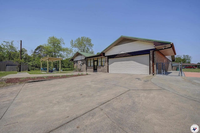 view of home's exterior with a gate, fence, concrete driveway, an attached garage, and brick siding
