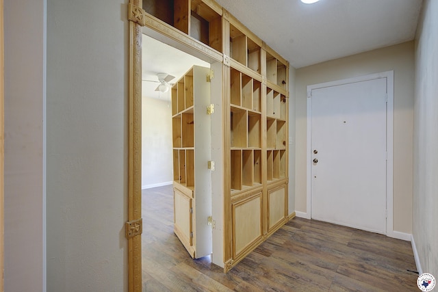 mudroom featuring baseboards and dark wood-type flooring