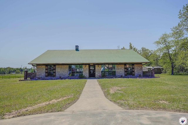508 E Fannin St, Dekalb, TX 75559 - view of front of house with brick siding, a front yard, a chimney, and metal roof