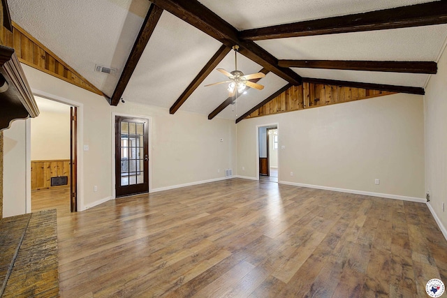unfurnished living room with a ceiling fan, vaulted ceiling with beams, wood-type flooring, baseboards, and visible vents