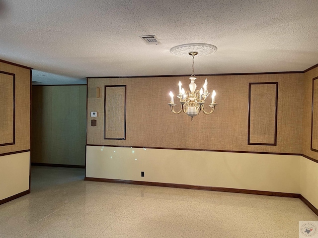 unfurnished room with a notable chandelier, crown molding, and a textured ceiling