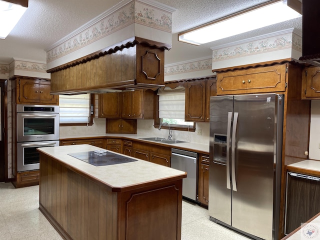 kitchen with sink, a center island, a textured ceiling, and appliances with stainless steel finishes