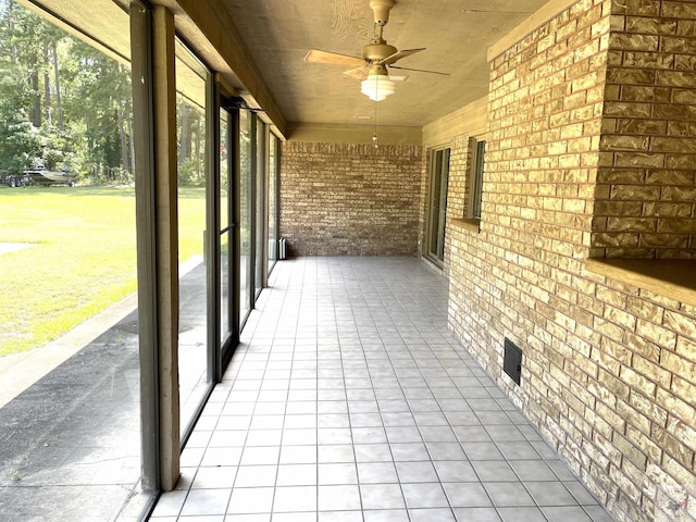 unfurnished sunroom featuring ceiling fan