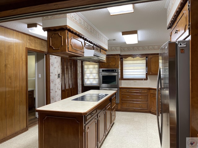 kitchen featuring crown molding, a textured ceiling, a center island, wood walls, and stainless steel appliances