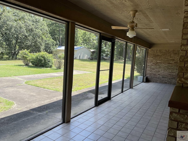 unfurnished sunroom featuring ceiling fan and wooden ceiling