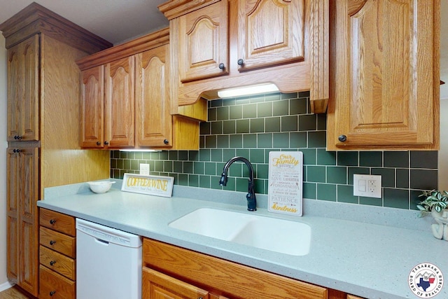 kitchen featuring light countertops, white dishwasher, a sink, and tasteful backsplash
