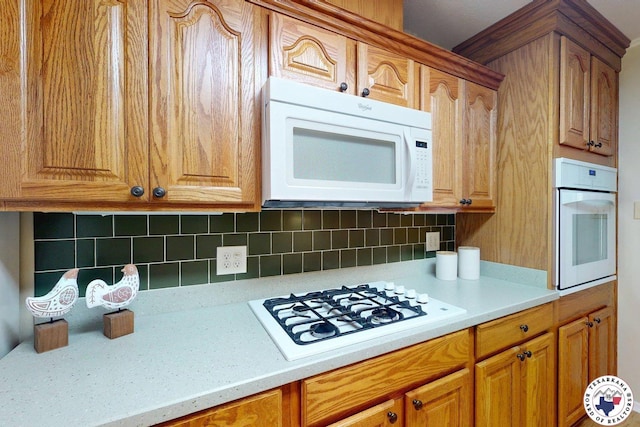 kitchen with light countertops, brown cabinets, backsplash, and white appliances
