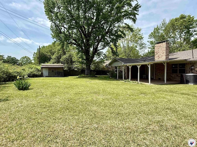 view of yard with central air condition unit and a patio area