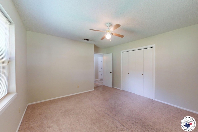 unfurnished bedroom with a closet, baseboards, carpet flooring, and visible vents