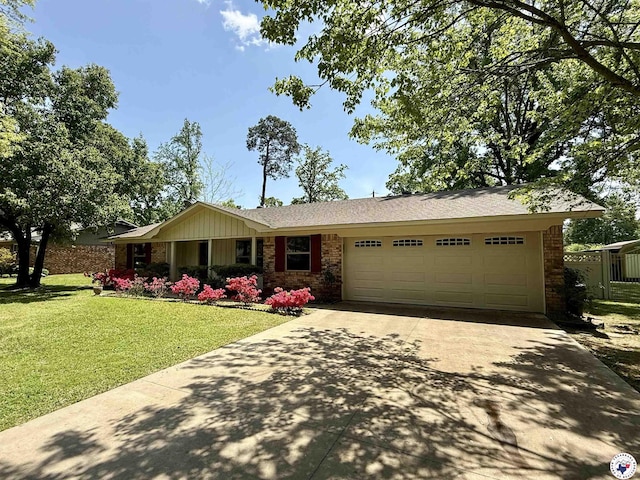 ranch-style house with an attached garage, concrete driveway, a front lawn, and brick siding