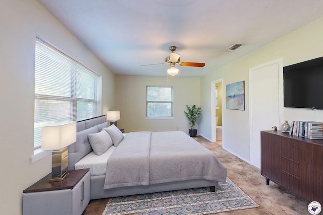 bedroom with ceiling fan, light carpet, ensuite bath, baseboards, and visible vents