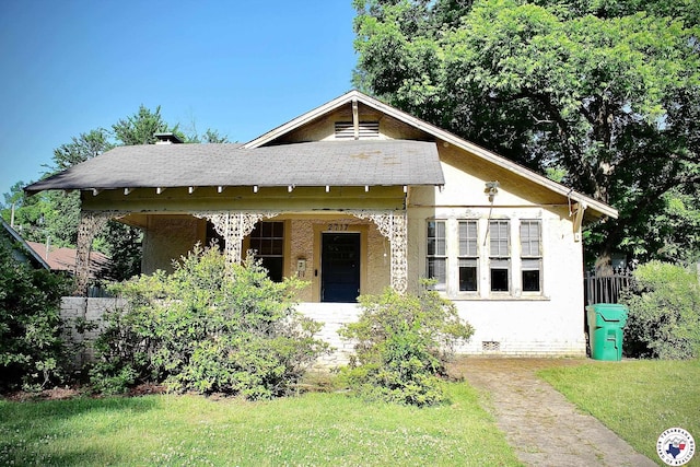 bungalow-style house with stucco siding, crawl space, fence, a front lawn, and a shingled roof