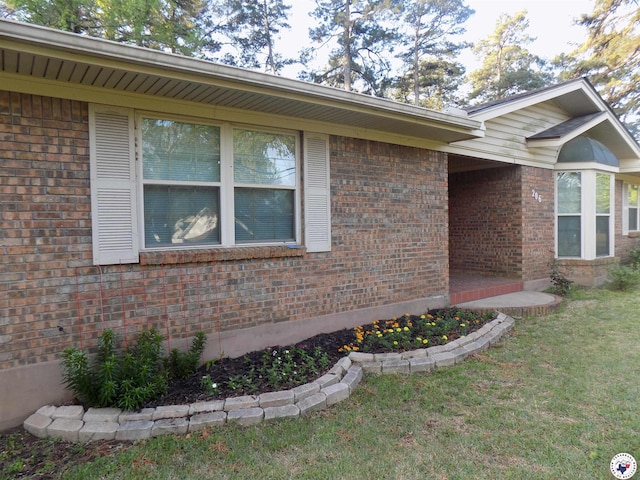 view of home's exterior featuring a lawn and brick siding