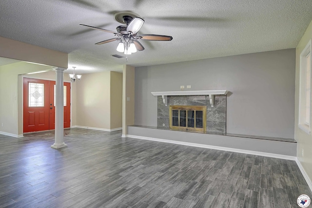unfurnished living room with a textured ceiling, ceiling fan, visible vents, ornate columns, and wood finished floors