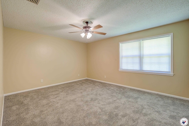 empty room featuring a textured ceiling, a ceiling fan, carpet flooring, and baseboards