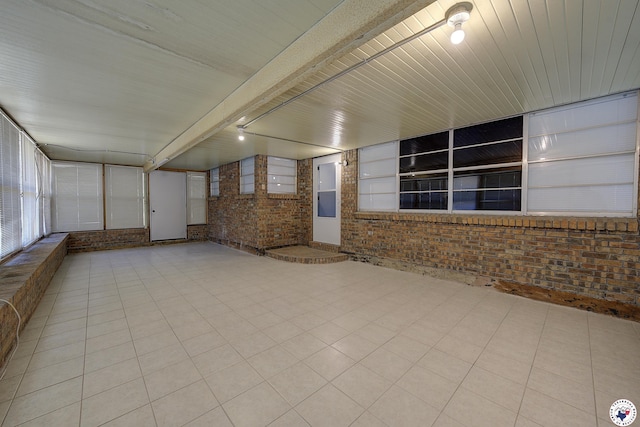 unfurnished sunroom with beam ceiling