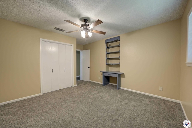 unfurnished bedroom featuring a closet, visible vents, carpet, baseboards, and a textured ceiling