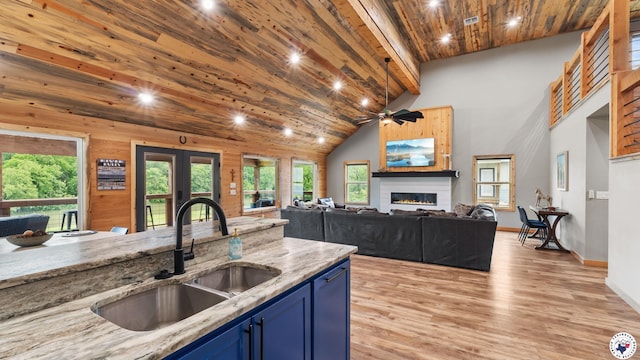 154 Serenity Loop, Glenwood, AR 71943 - kitchen with blue cabinetry, a sink, a glass covered fireplace, light wood-style flooring, and wood ceiling