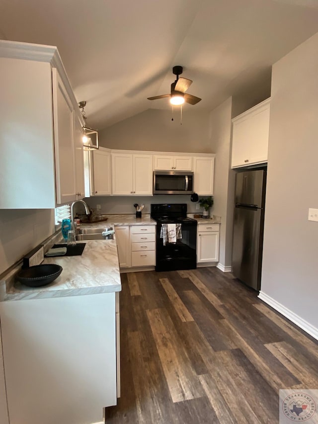 kitchen featuring appliances with stainless steel finishes, hanging light fixtures, sink, white cabinets, and dark wood-type flooring