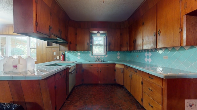 kitchen featuring a textured ceiling, sink, backsplash, kitchen peninsula, and electric range