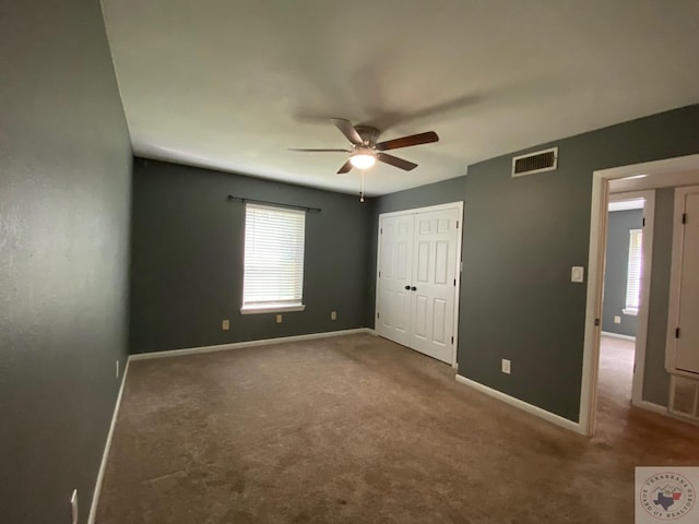 unfurnished bedroom featuring a closet, ceiling fan, and carpet floors