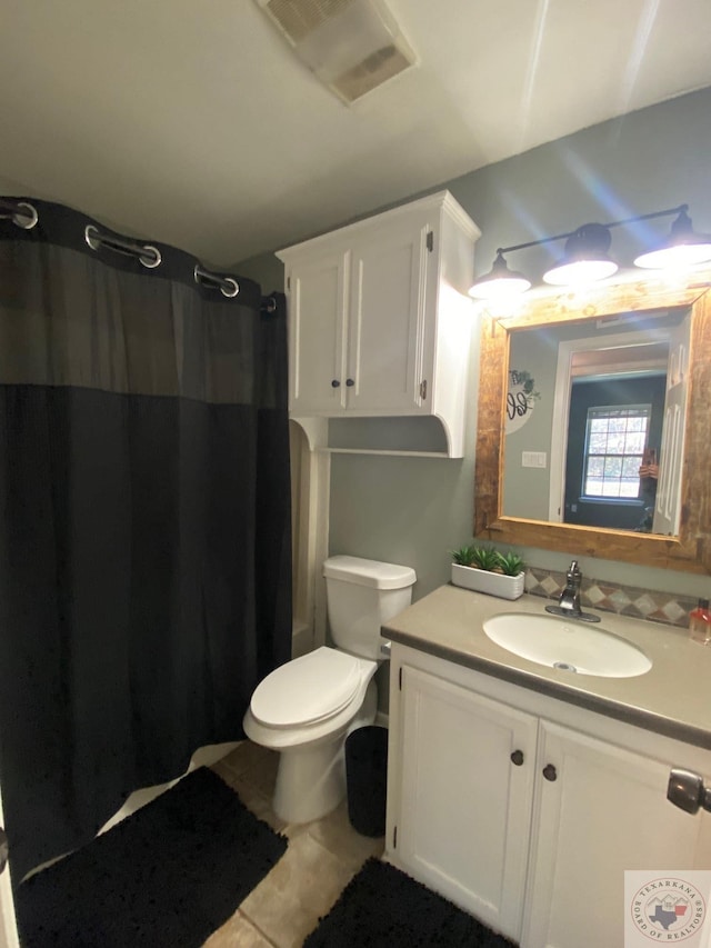 bathroom with curtained shower, toilet, tile patterned flooring, and vanity