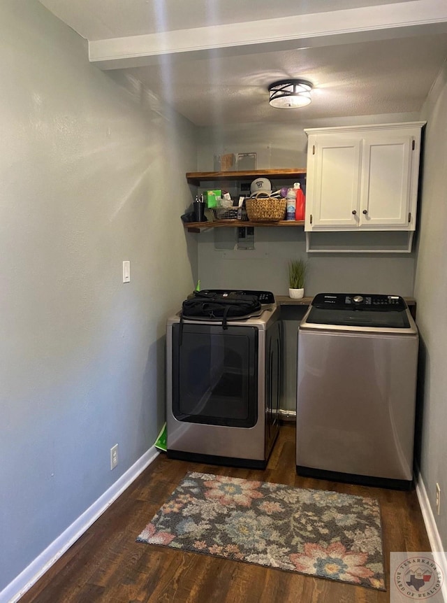 washroom featuring cabinets, dark hardwood / wood-style flooring, and washing machine and dryer