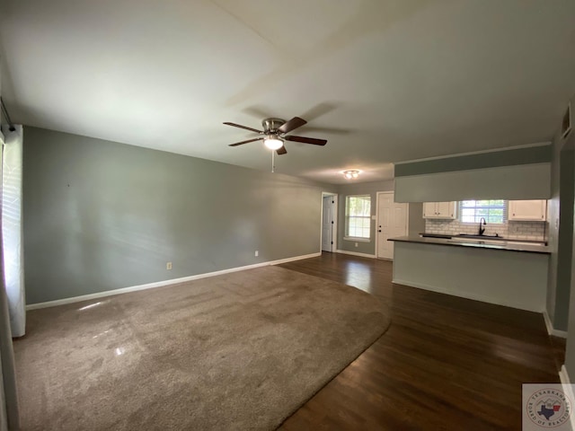 unfurnished living room with sink, ceiling fan, and dark hardwood / wood-style floors