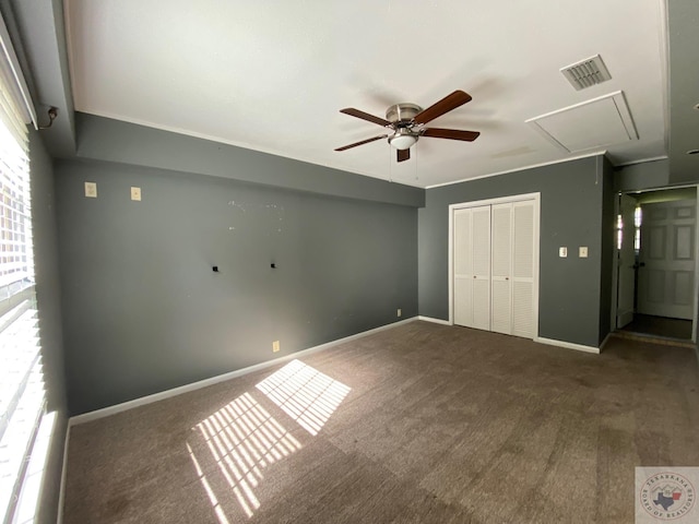 unfurnished bedroom with dark colored carpet, a closet, and ceiling fan