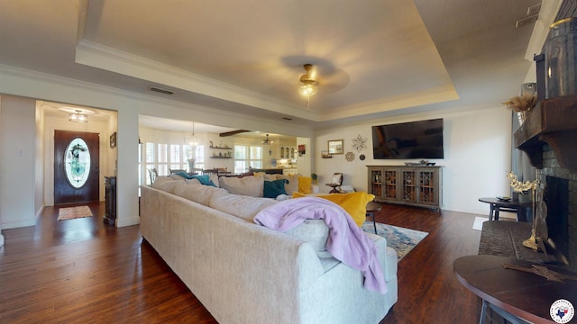 6010 Shadyside Ln, Texarkana, TX 75503 - living room featuring a tray ceiling, ceiling fan, dark wood-style floors, a brick fireplace, and ornamental molding